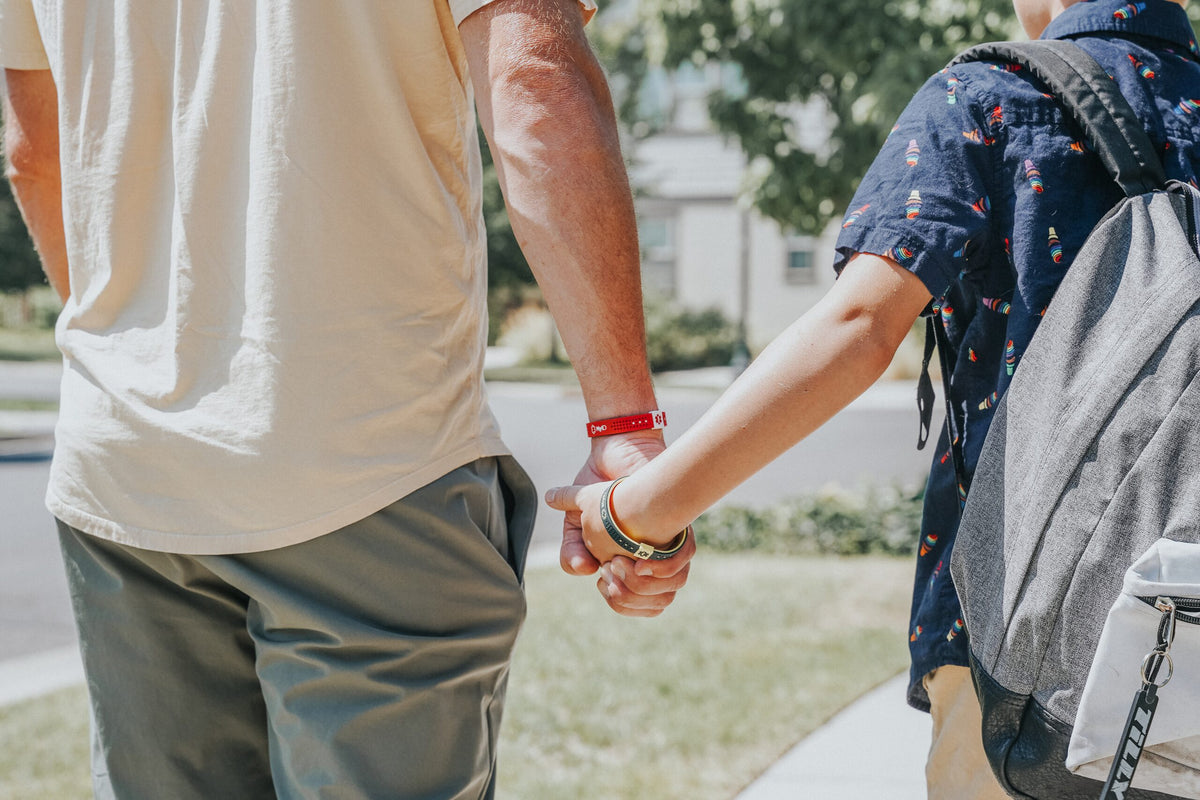 Couple holding hands, one wearing a red MyID medical ID bracelet